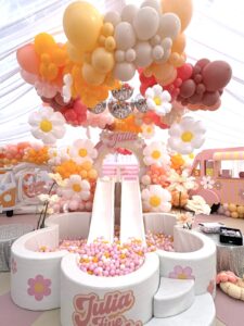 Glijbanen met heel veel ballonnen er omheen en madelief bloemen folies