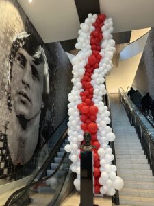 een organic ballonnen tapijt van 12 m lang in de Ajax kleuren wit rood Geplaatst achter het Johan Cruyff hoofd beeld